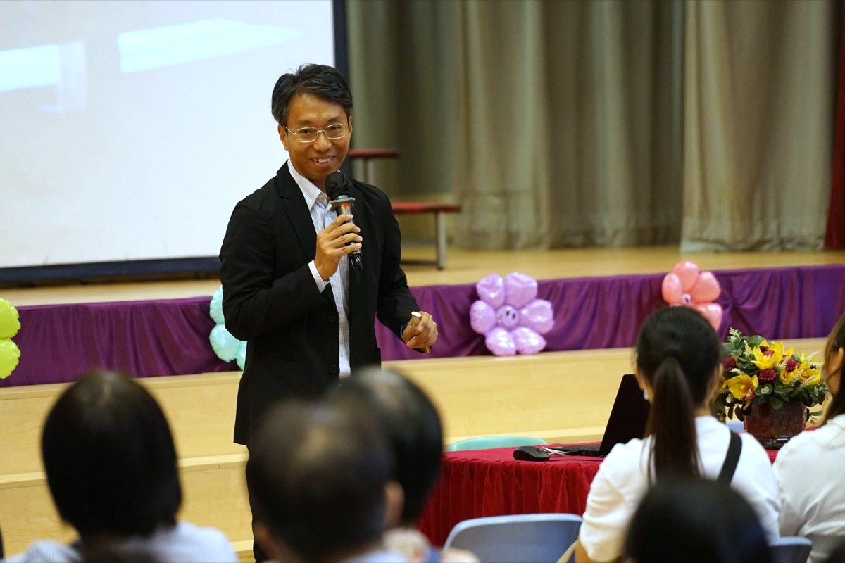 導師在學校禮堂手持咪高峰主持家長講座